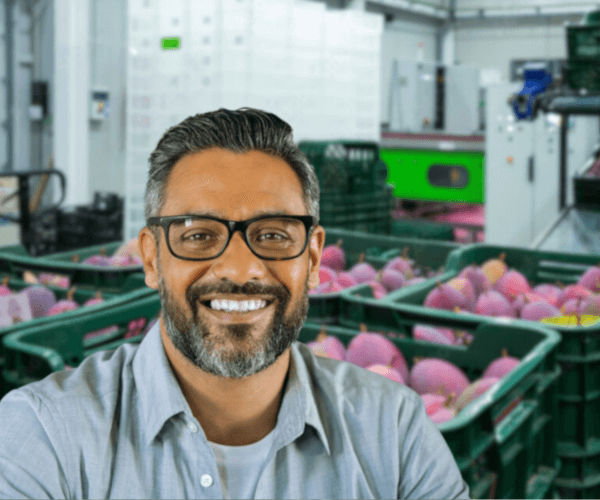 Siddharth Aam Aadmi, a greying businessman, stands in front of crates of mangoes.